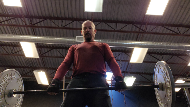 Robbie Ferguson doing deadlifts with a 75 lb barbell.